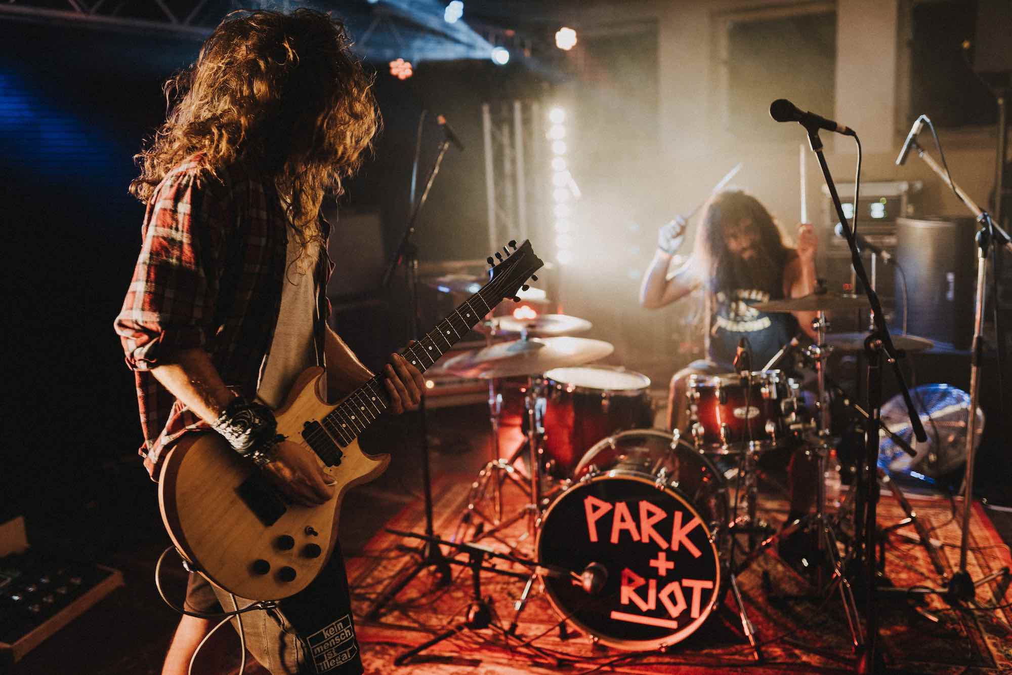 Portfolio (Hardcore / Noise) Was ein Abriss! Weniger ist dann manchmal doch mehr – so gelernt an dem Beispiel von Park+Riot aus Leipzig. Samuel und Micha machen Gitarre und Drums, und das reicht hier um ordentlich Randale loszutreten. Irgendwie erinnern sie an mid 90er ChaosCore, mit einer irren Schippe Postrock und den nötigen kleinen Melodien, die die Songs im Kopf hängen bleiben lassen. Trotz alledem sind die Songs enorm dicht und stimmig, wirken nicht zusammengestückelt oder heterogen. Was die Songs eint ist auf jeden Fall ein Gespür für Rhythmik und Melodie, was auch den zerfahrensten Song irgendwie wieder auf die Spur bringt und fast schon Pop-Momente erklingen lässt. So treffen bei „The End“ zum Beispiel Spoken Words-Part auf black metallige Knüppel-Attacken, bei „Clouds“ treibende Schweden-Core Parts auf postmetallisches Atmo-Geklimper um dann wieder mit viel Effet Fahrt aufzunehmen und schliesslich in einem deftigen Neckbreaker-Mosh zu enden – Toll! Hier sind drei Bands in einer vereint, und die eine hat obendrauf noch was zu sagen. Wenn bei „Long Run“ der ganz Laden den Refrain mitgröhlt, weiß der Letzte spätestens, dass er bei einer ganz wichtigen Sache mit dabei ist.